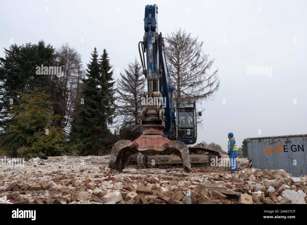 Operai che utilizzano una macchina idraulica per la demolizione nella città abbandonata delle miniere di carbone, Mannheim, Germania Foto Stock
