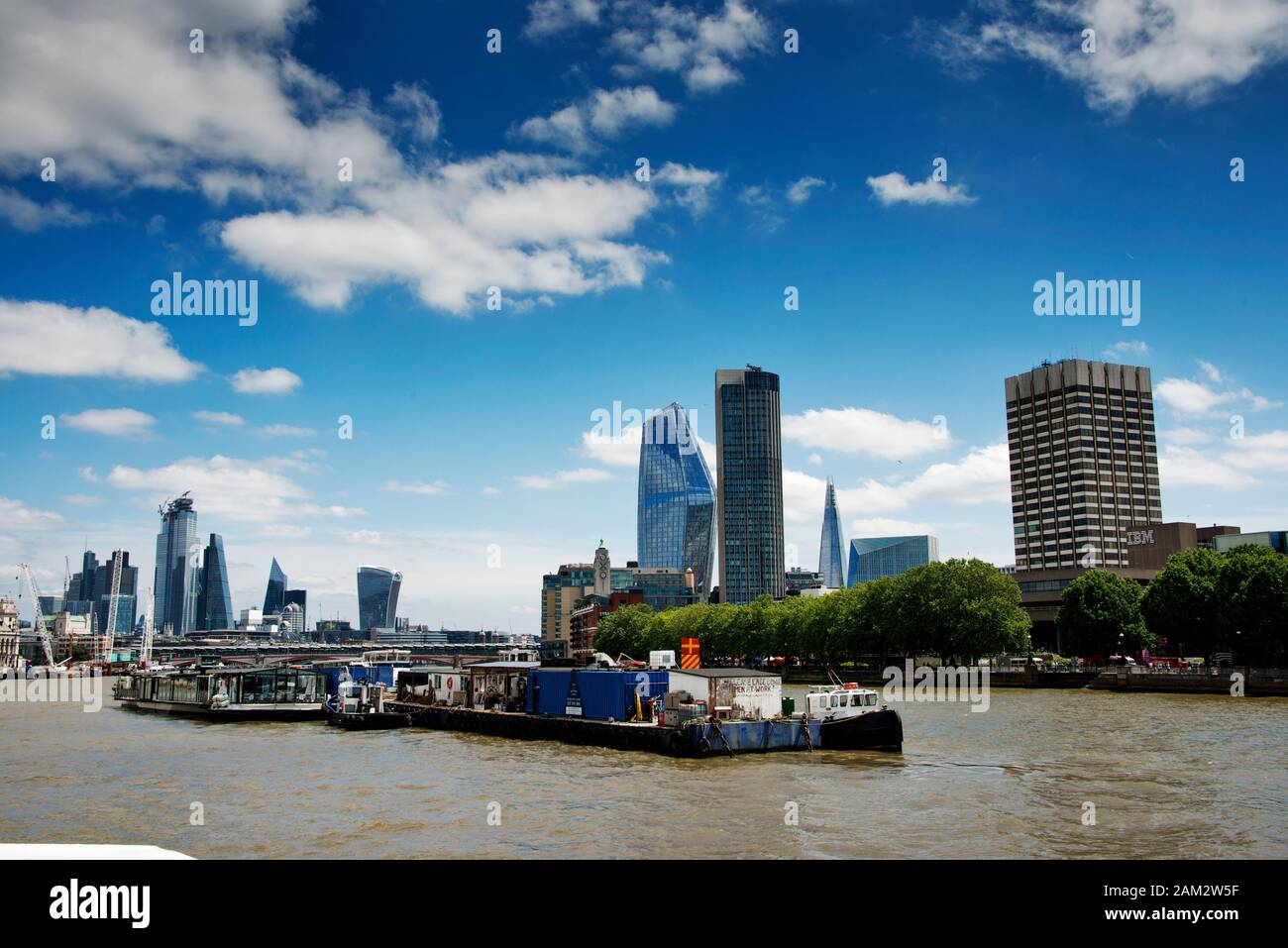 River Thames Londra Regno Unito. London Skyline con chiatte di barche turistiche ed edifici moderni in vetro su entrambi i lati del fiume Foto Stock