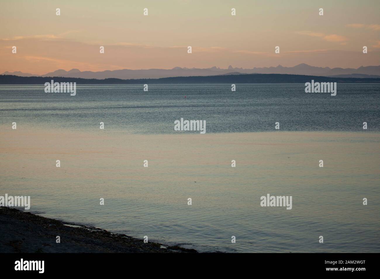 Idilliaca scena costiera con solitudine boa e montagne sullo sfondo, Vancouver Island, British Columbia, Canada Foto Stock