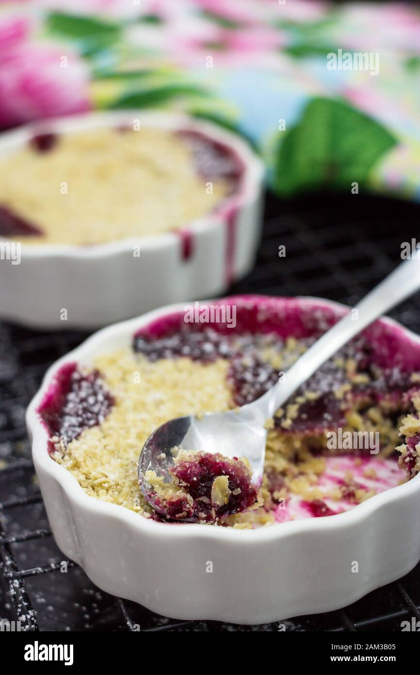 Delizioso crumble fatto in casa con frutti di bosco in ramekins porzionati. Colazione sana. Messa a fuoco selettiva Foto Stock