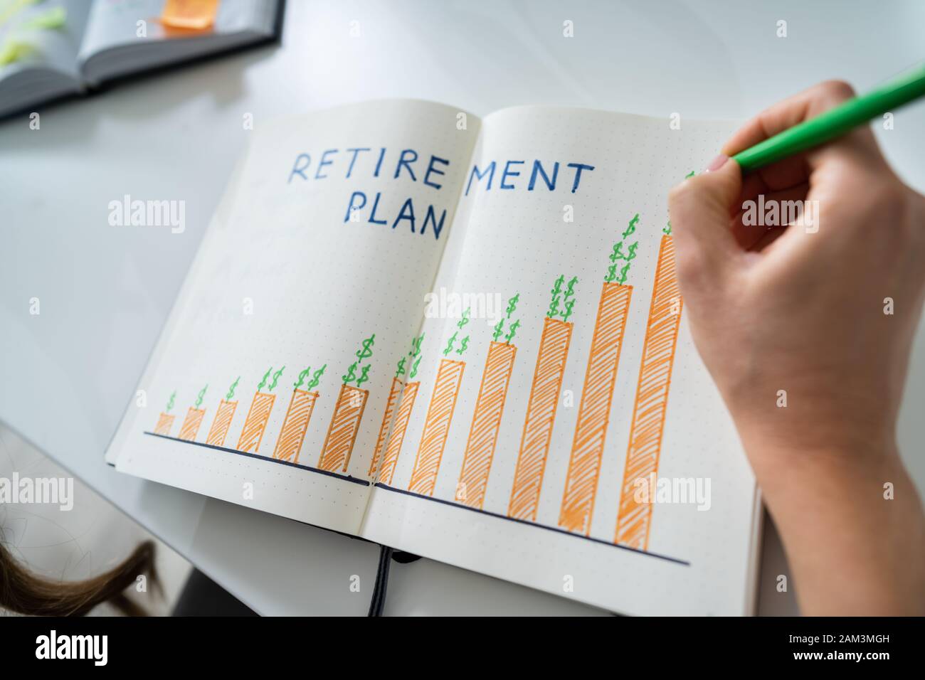 Vista in elevazione di una mano umana disegno piano di pensionamento il concetto di crescita su Notebook Foto Stock