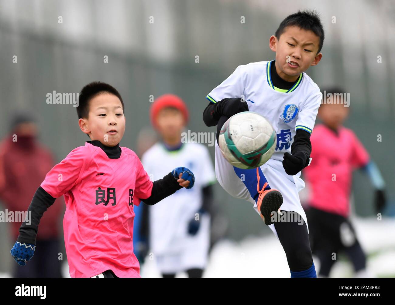 (200111) -- Pechino, 11 genn. 2020 (Xinhua) -- Liu Yuze (R) di Tiger Club dell'U10 del team vies con Yan Zixuan di Langyue Club dell'U10 del team durante il loro incontro a Pechino 2019-2020 Youth Football Club League a Pechino Capitale della Cina, a gennaio 11, 2020. (Xinhua/Wu Wei) Foto Stock