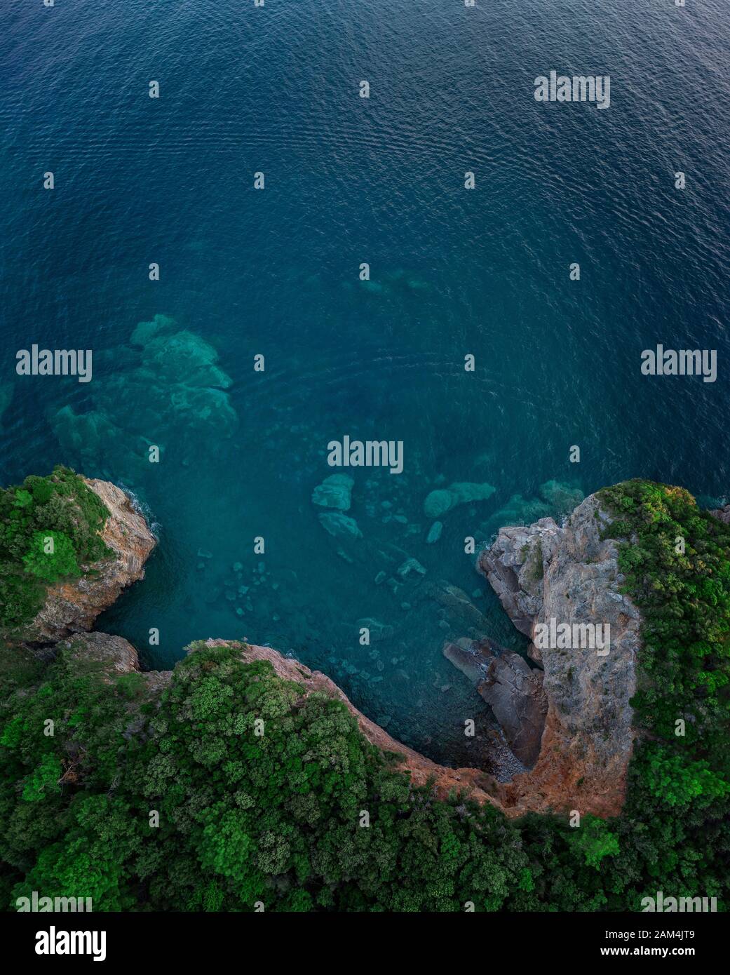 Vista aerea di una ripida scogliera, natura incontaminata della costa del Montenegro. Grotte Marine e insenature alternate sulla costa mediterranea Foto Stock