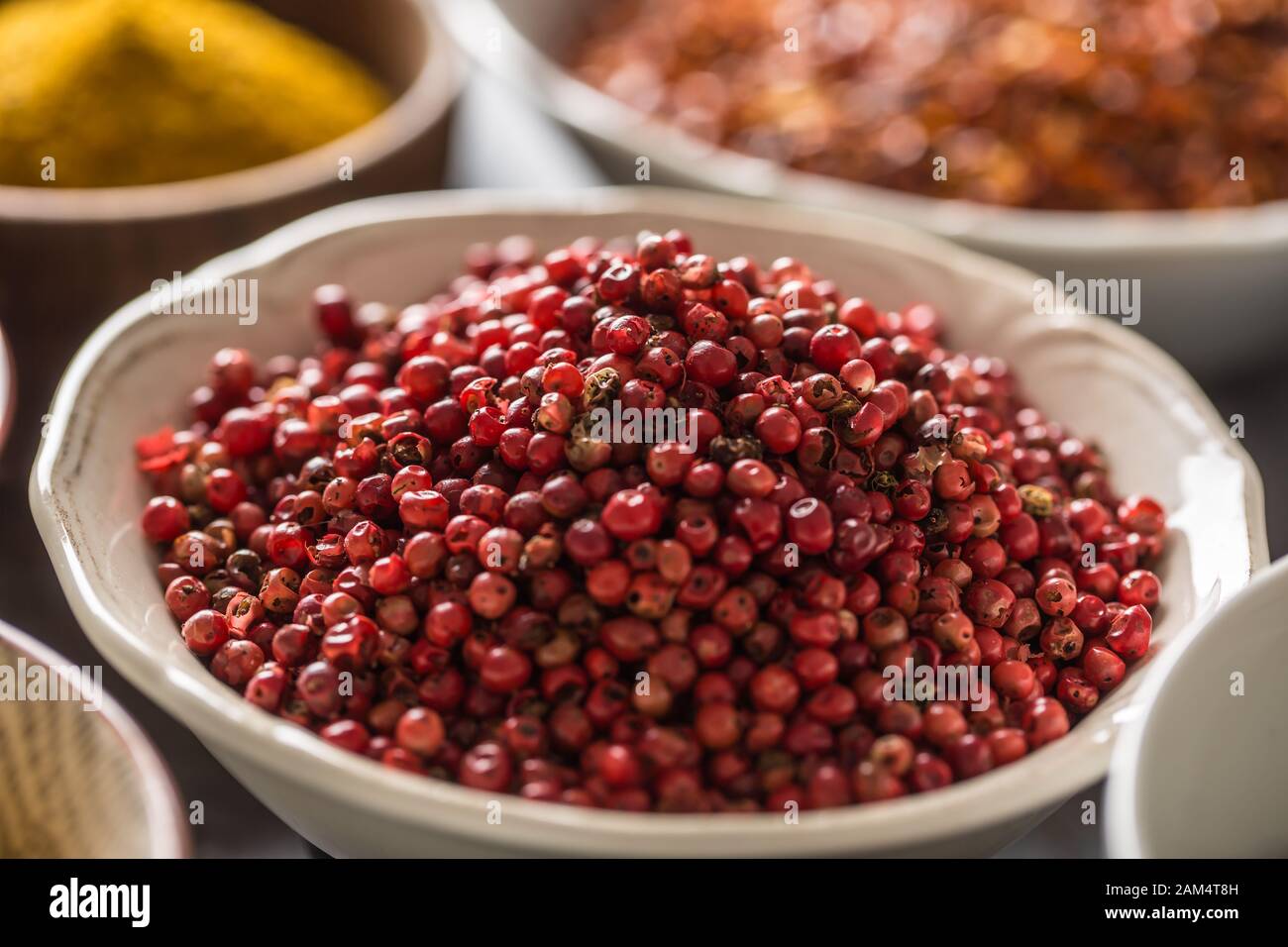 Pepe rosa e varietà di spezie ed erbe in ciotole Foto Stock