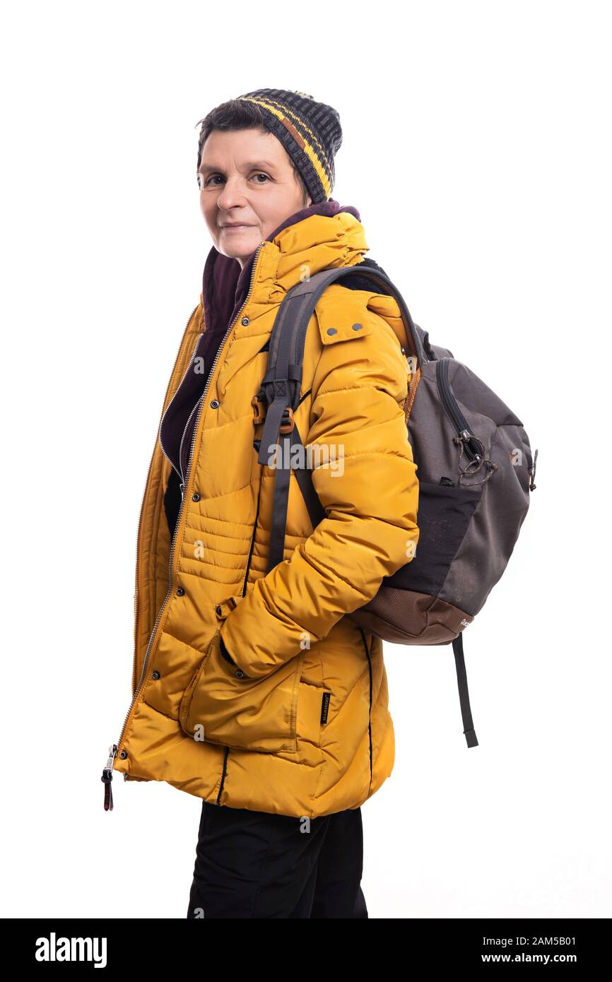 Donna escursionista con giacca in puffer, stivali da trekking invernali,  ghette e mittens, si trova accanto al cartello arrugginito sulla vetta  Leaota, Carpathian moun Foto stock - Alamy