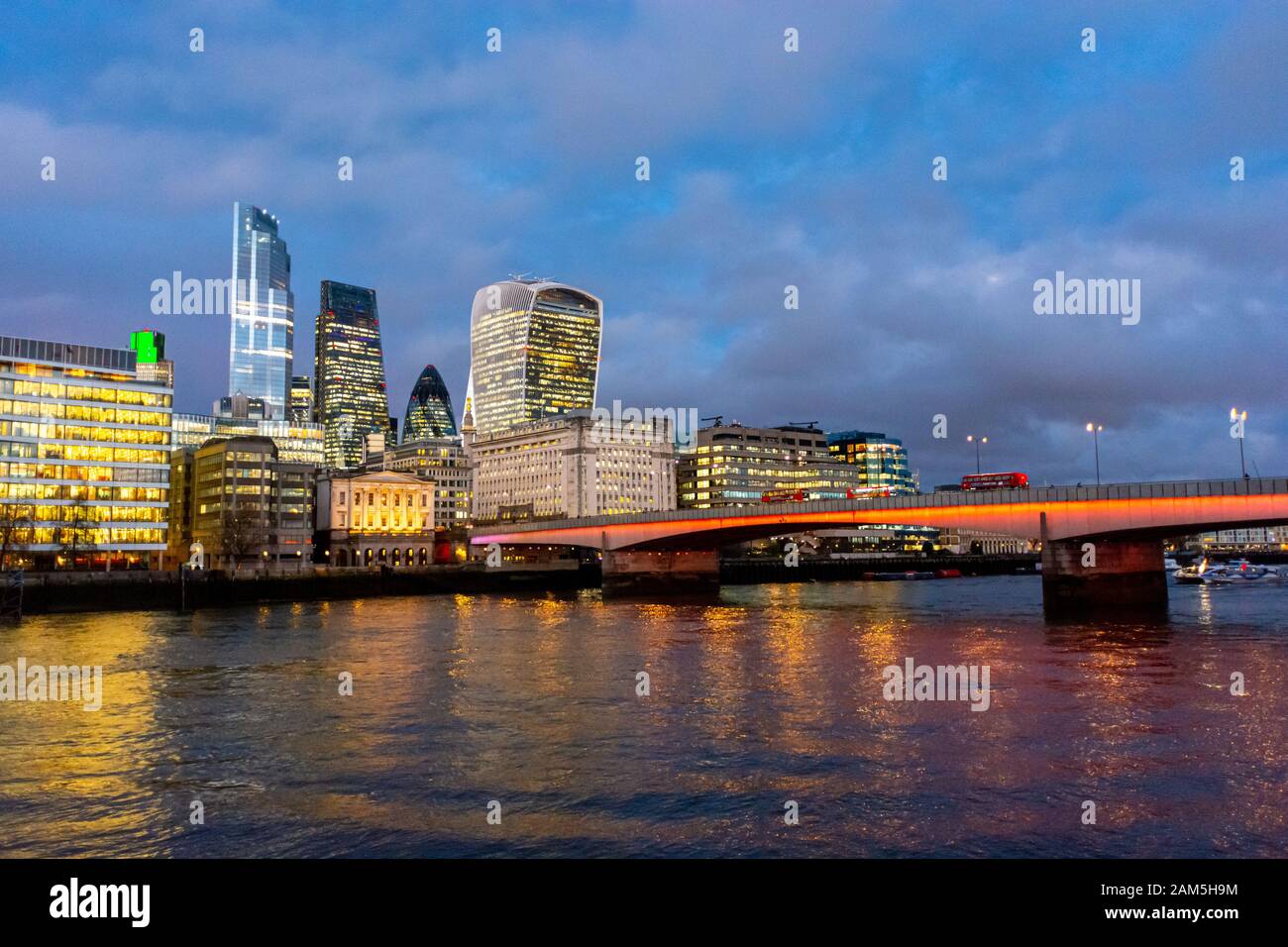 Skyline della città di Londra in una serata invernale con London Bridge e il Tamigi in primo piano Foto Stock