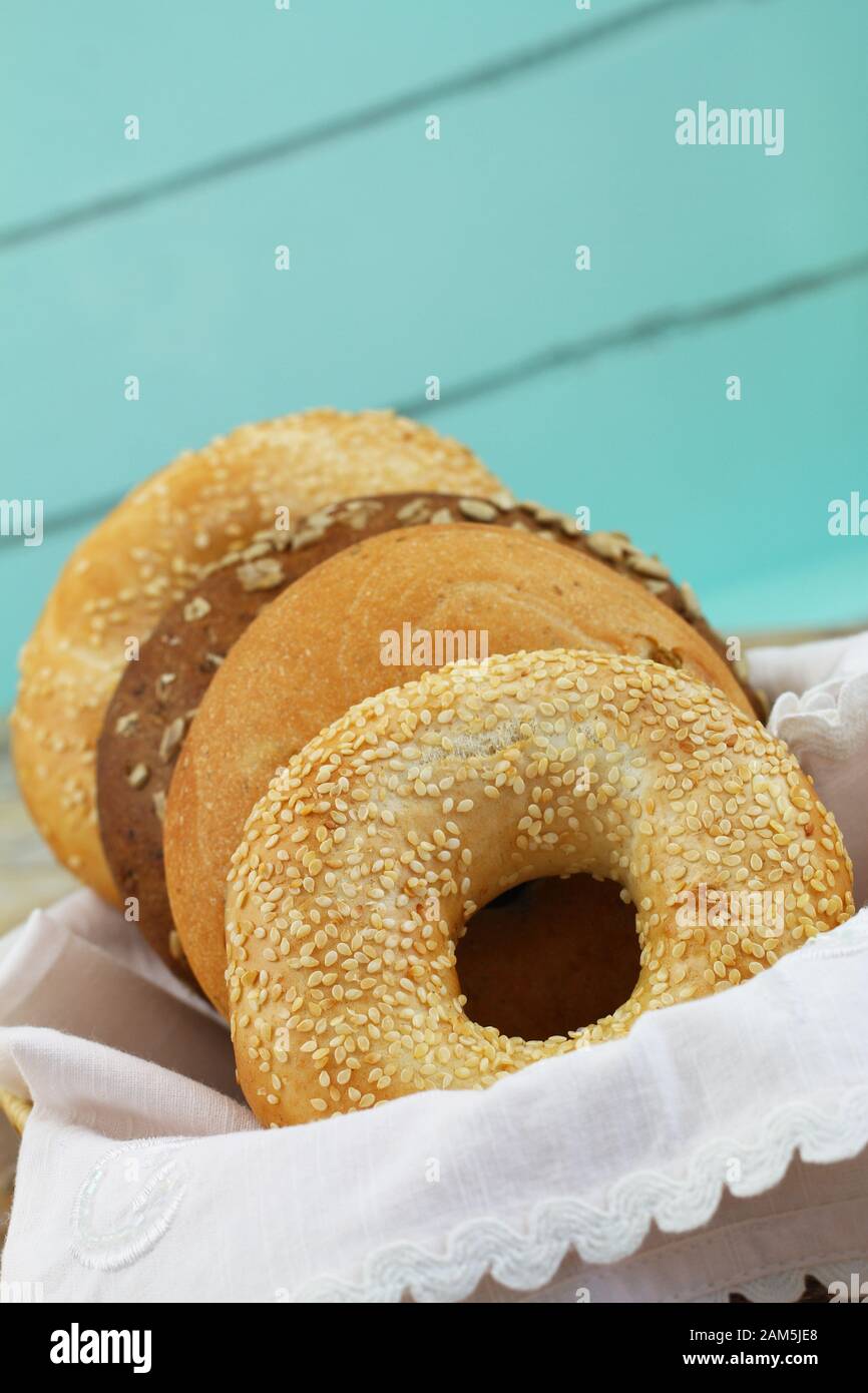 Bagel appena sfornati nel cestino del pane su sfondo blu con spazio per le copie Foto Stock