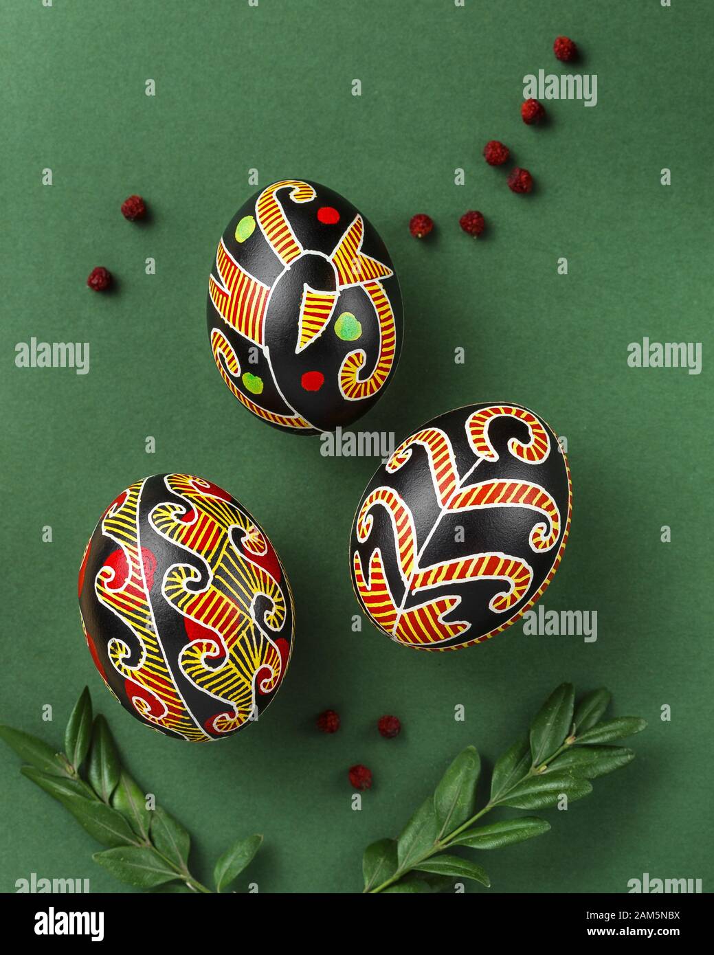 Pysanky, uova di Pasqua Ucraina decorate con cera-resist tintura tecnica, buxus brunch albero e frutti di bosco di draye su sfondo verde Foto Stock