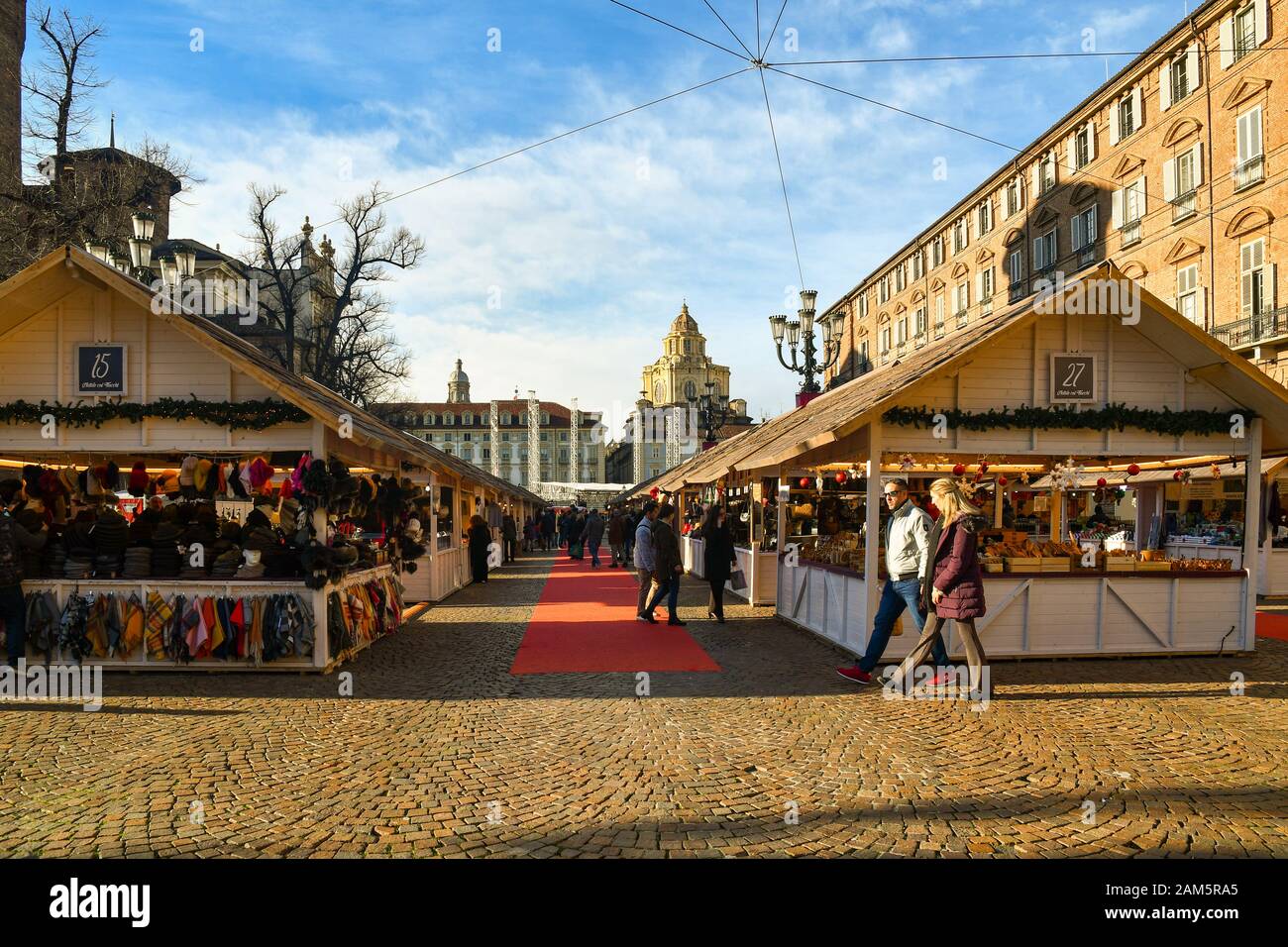 Vista sul tradizionale mercatino di Natale in Piazza Castello con gente a piedi e shopping in una soleggiata vigilia di Natale, Torino, Piemonte, Italia Foto Stock