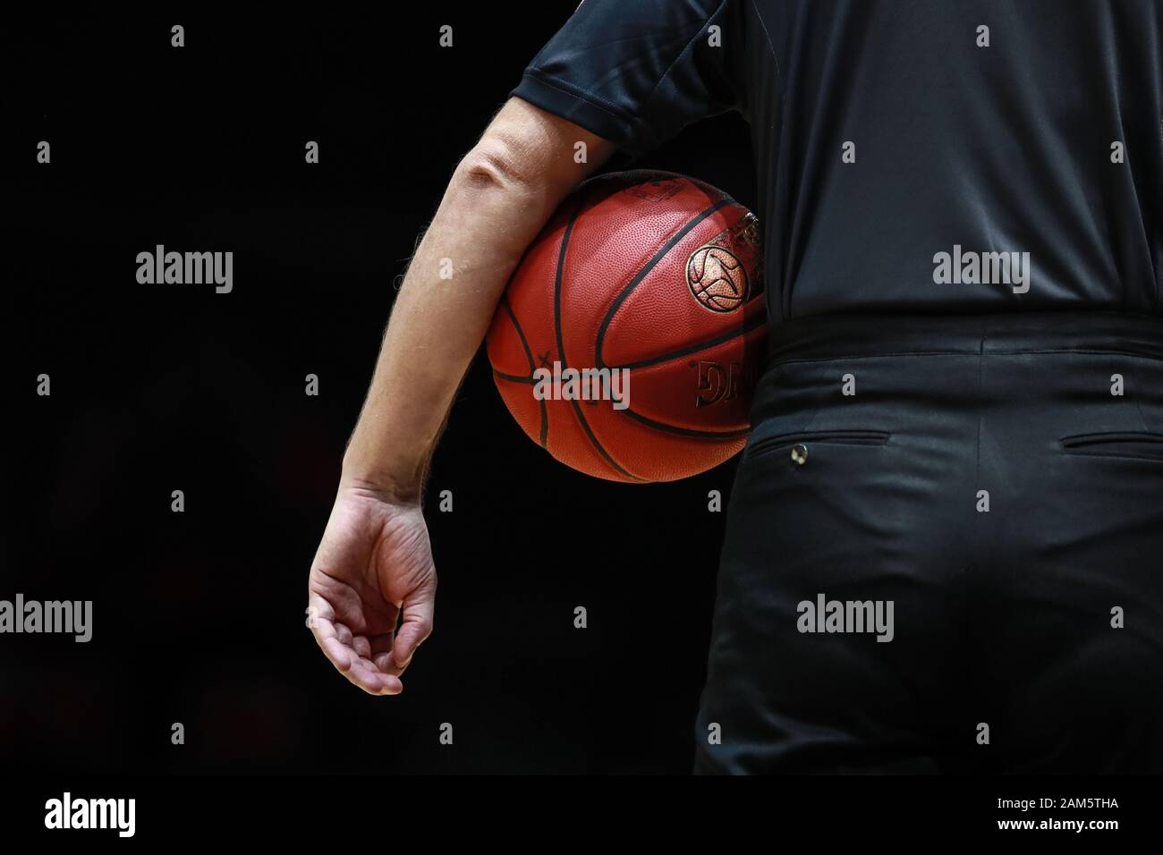 Braunschweig, Germania, 14 dicembre 2019: Un arbitro con uniforme nera tiene la palla ufficiale durante un gioco Basketball BBL Pokal Foto Stock