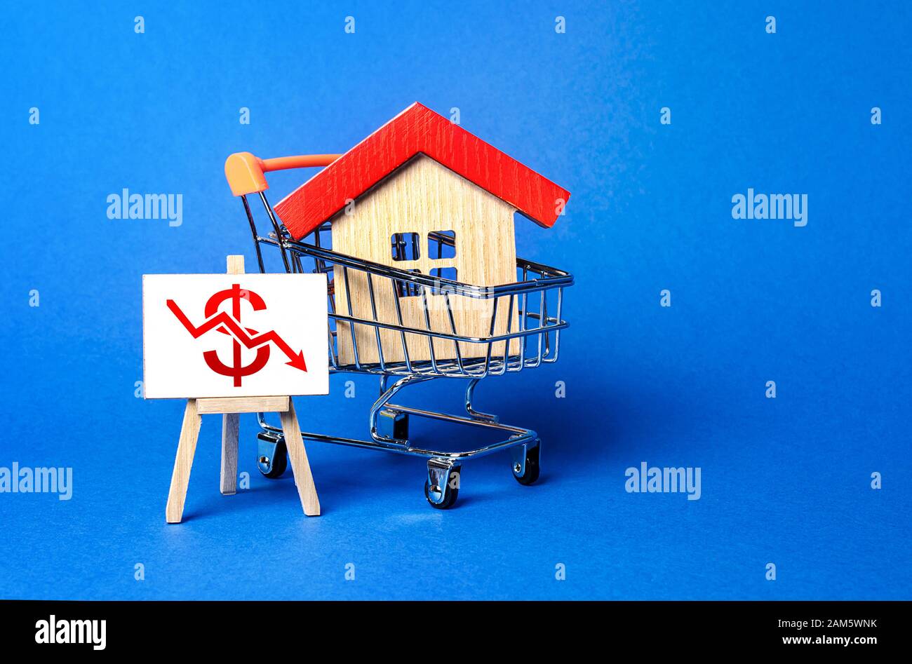 Casa in un carrello e un cavalletto con una freccia rossa del dollaro verso il basso grafico. Caduta del mercato immobiliare. Affitto economico. Riduzione della domanda, recessione. Valore cos Foto Stock