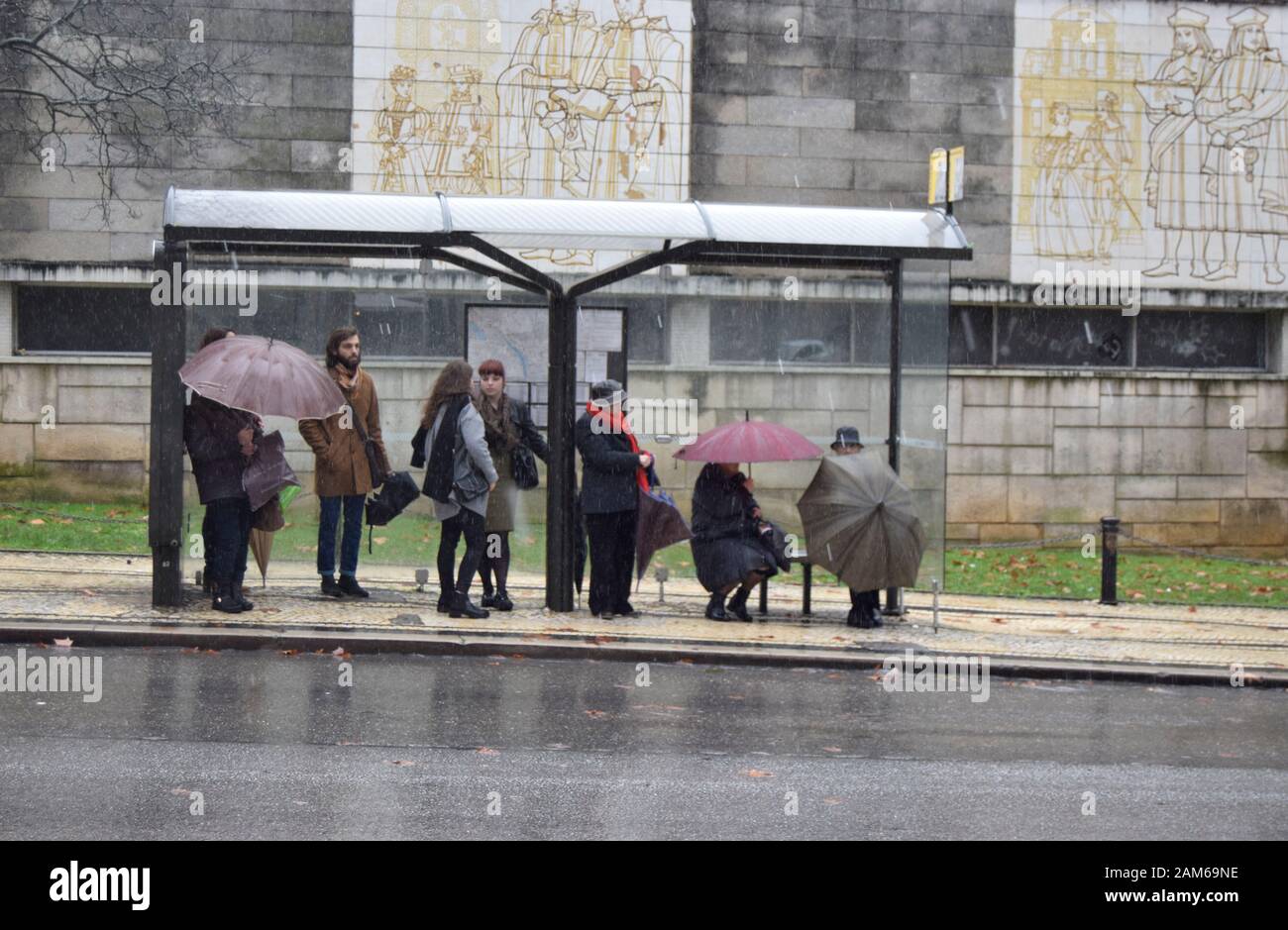 COIMBRA, PORTOGALLO - 04 gennaio 2016 - le persone cercano di rimanere asciutte durante le piogge intense nella Repubblica di Praca nel centro di Coimbra, Portogallo Foto Stock