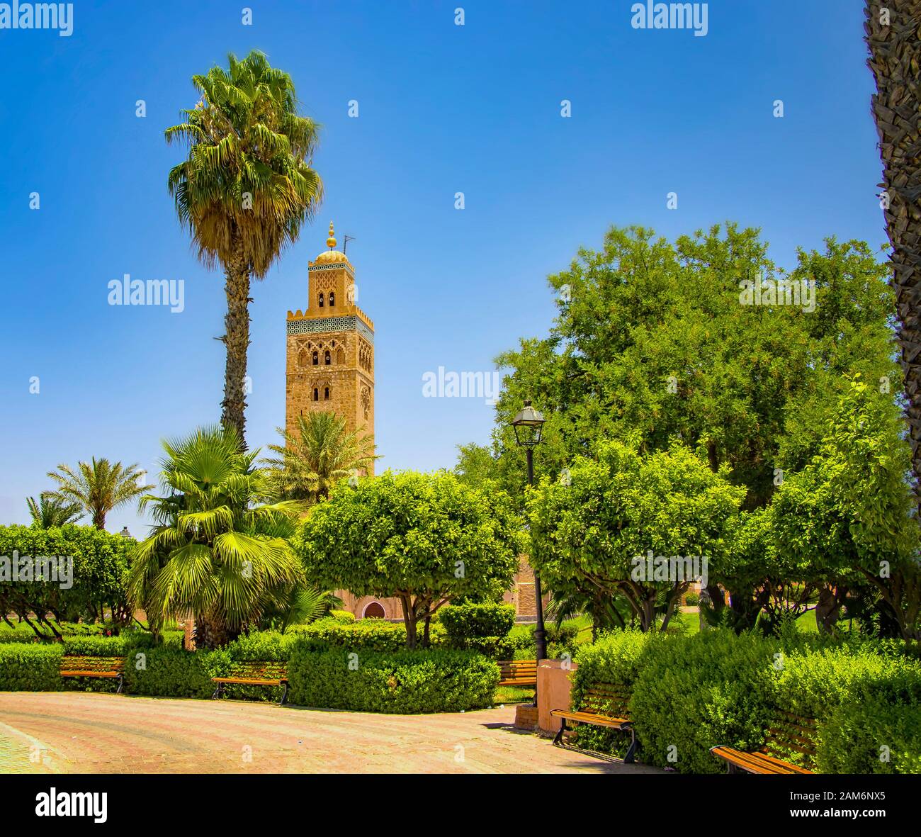 La Moschea di Koutoubia minaret al quartiere della medina di Marrakech, Marocco. C'è un bellissimo giardino verde con palme. Blue Sky è in background. Foto Stock