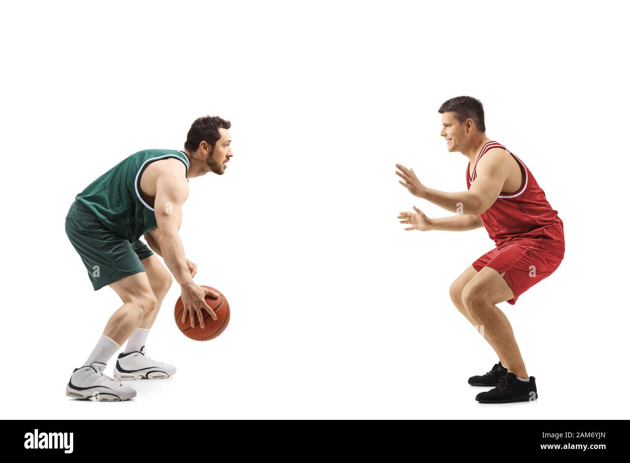 A piena lunghezza profilo colpo di due giocatori di basket a partire da opposte squadre giocare una partita isolata su sfondo bianco Foto Stock