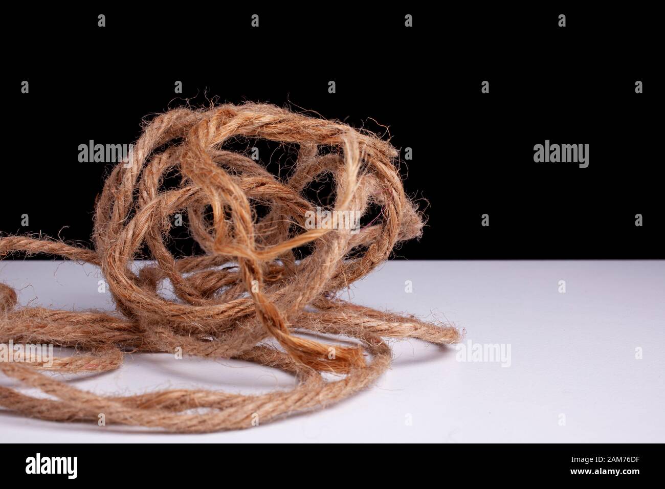 Confusione disorganizzata. Aggrovigliato, stress, confuso, complicato, immagine concettuale. Grande palla di corda aggrovigliata e di canapa Foto Stock