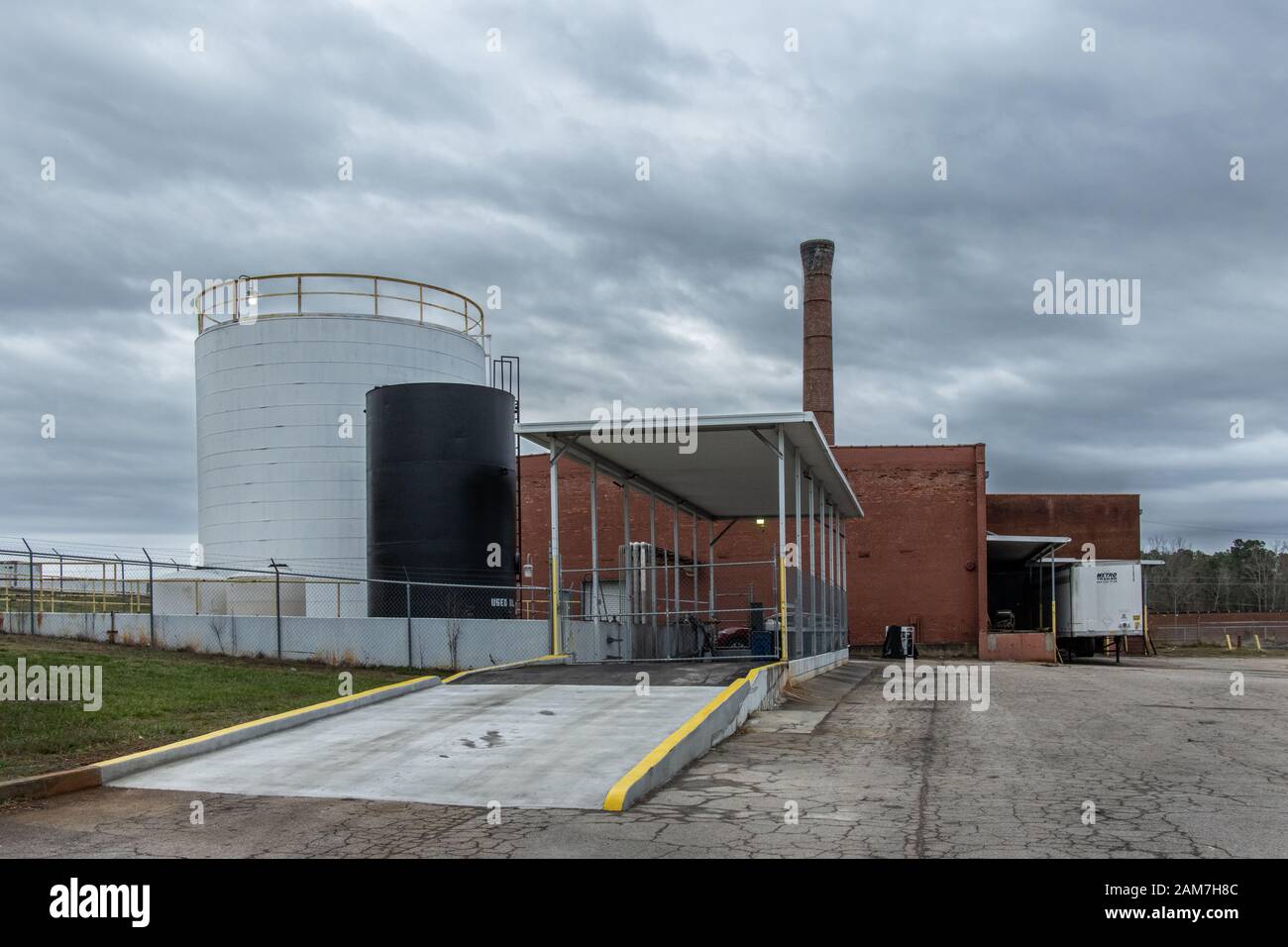 Chicopee Mills - Hall County, Georgia. Nuvole tempestose nel cielo sopra serbatoi di stoccaggio e la parte vecchia dello stabilimento di produzione Chicopee Mills. Chicope Foto Stock