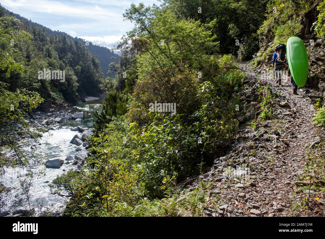 Camminando lungo il sentiero Old Ghost Road, Lyell fino a Seddonville, Nuova Zelanda. I kayakers trasportano il loro ingranaggio verso la capanna del punto Dell'Esemplare per pagaiare il fiume Mokinhinui Foto Stock