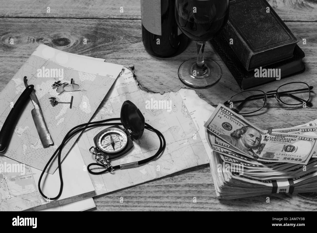 Mappa, Bussola, vino, denaro, libri, rasoio, polsini, tie tack e bicchieri pronti per un viaggio concetto, in bianco e nero, orizzontale Foto Stock