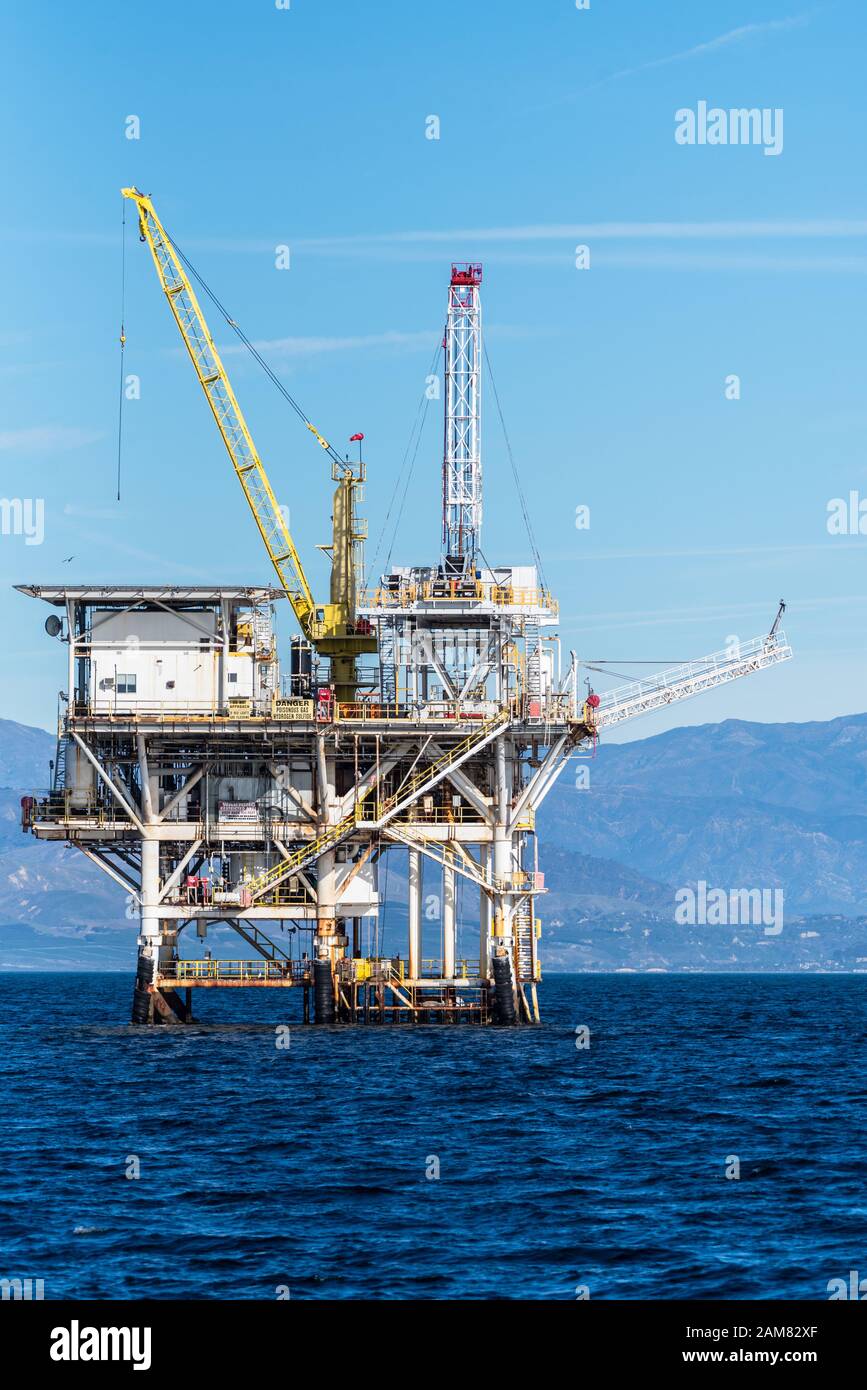 Piattaforma Gina nel canale di Santa Barbara si trova in alto sopra la linea d'acqua con la costa e le colline di Ventura sullo sfondo. Foto Stock