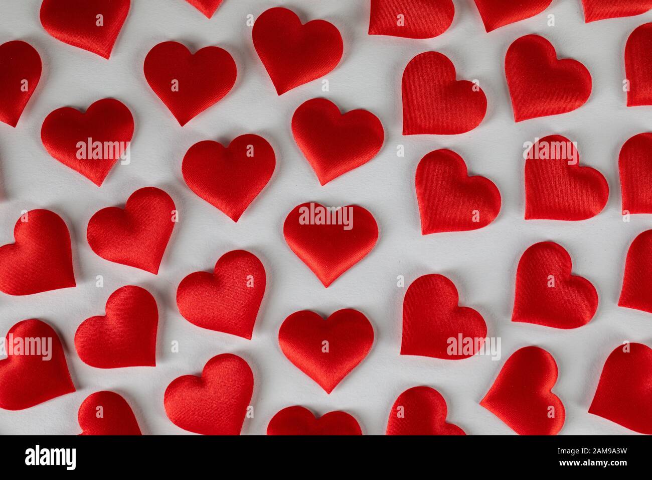 San Valentino molti cuori di seta rossa su sfondo bianco, concetto di amore Foto Stock