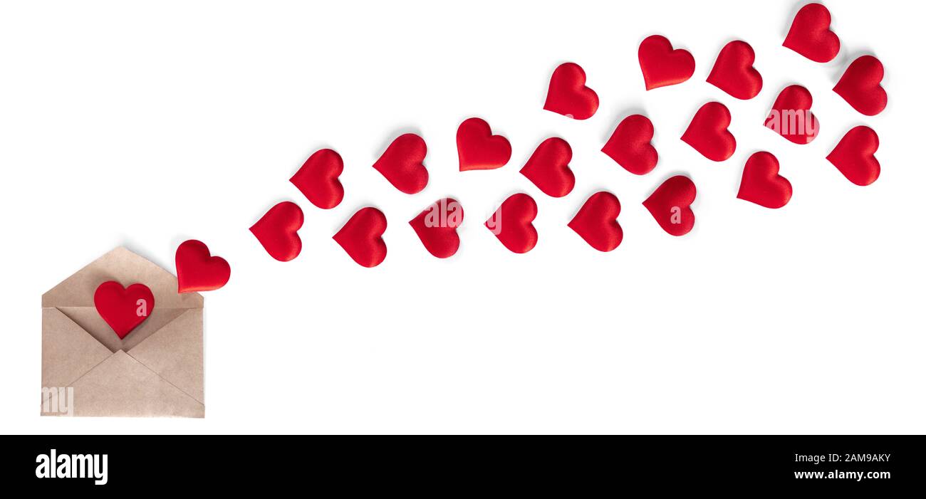 Il giorno di San Valentino lettera d'amore, busta di carta artigianale con cuori rossi diffusione heap su sfondo bianco. Foto Stock