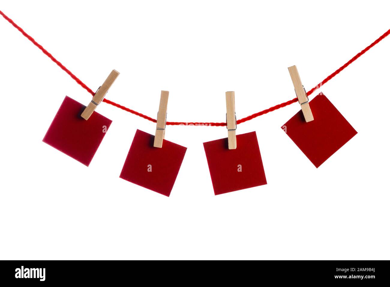 Set di quattro rosso vuoto note di carta tenuto su una stringa con clothespins isolati su sfondo bianco Foto Stock