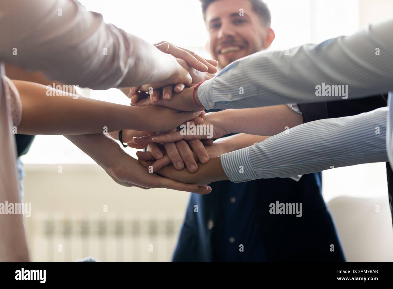 Il personale di successo si è accatastato le mani insieme per celebrare i risultati di lavoro riusciti closeup Foto Stock
