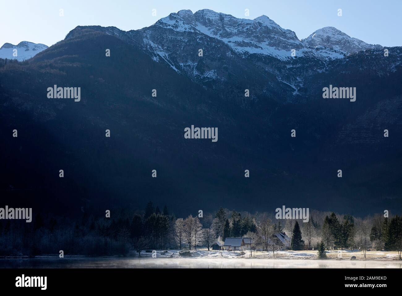 Cottage tradizionali sotto le alpi Giulie sulla riva del lago di Bohinj, slovenia Foto Stock