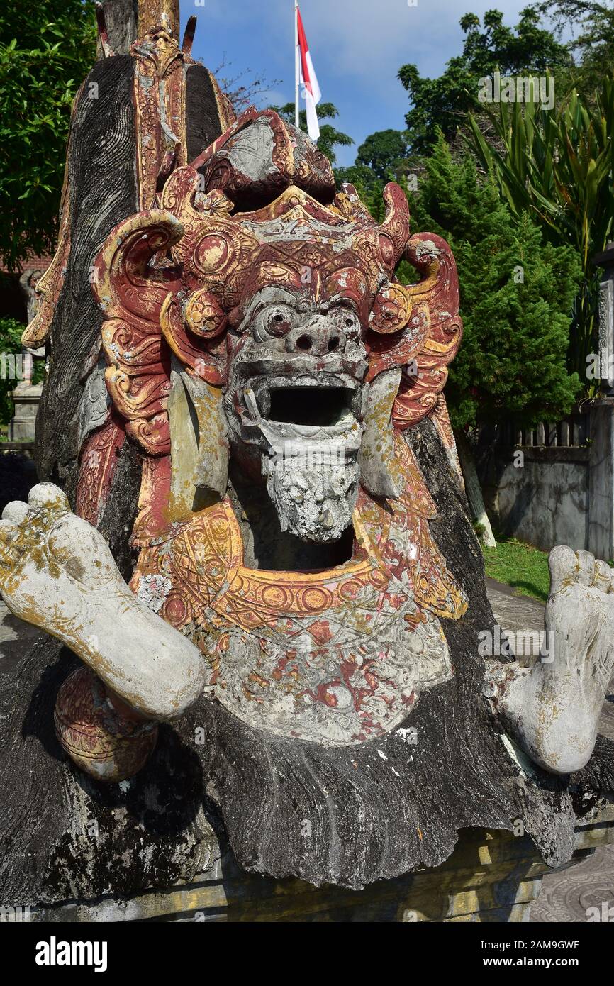 Dettaglio della statua di pietra demoniaca con vernice superficiale agli agenti atmosferici nei locali del palazzo d'acqua Tirta Gangga a Bali. Foto Stock