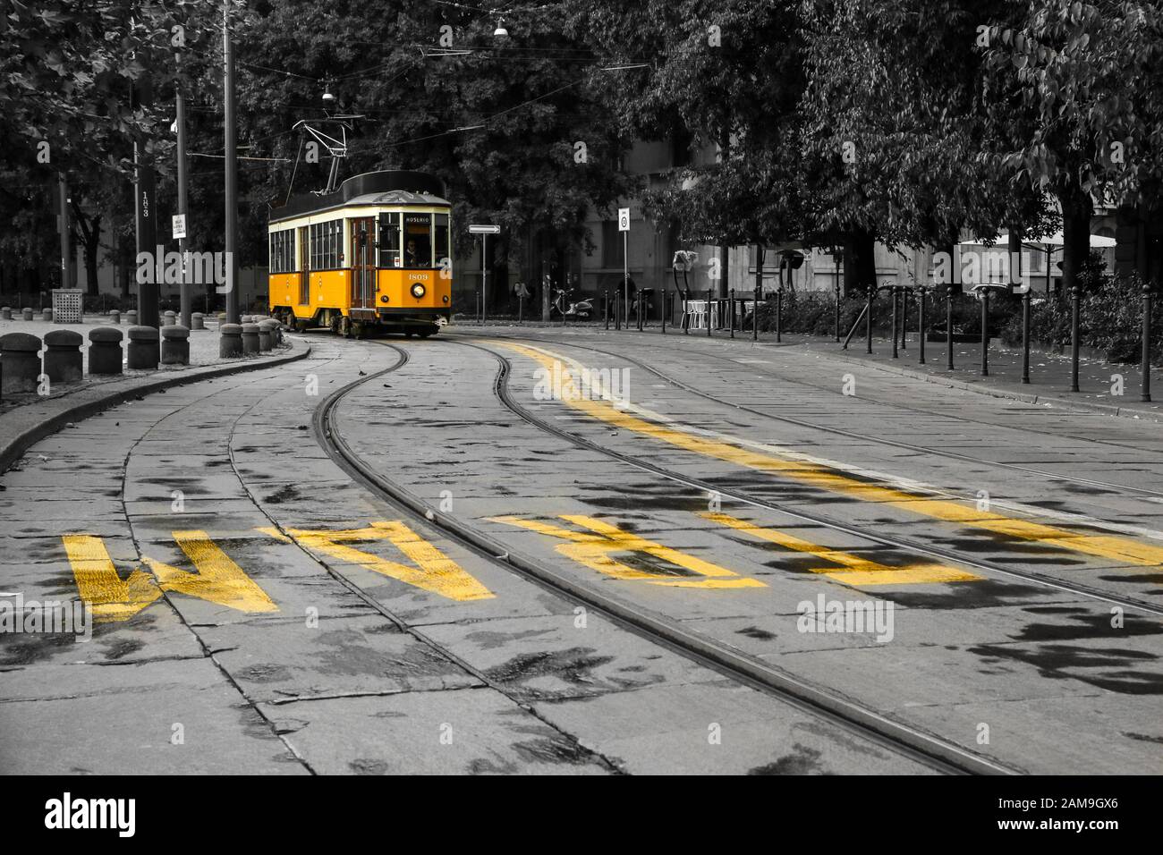 Una foto del tipico tram giallo a Milano, Italia, passando per il centro della città. Il tram è isolato su sfondo bianco e nero. Foto Stock