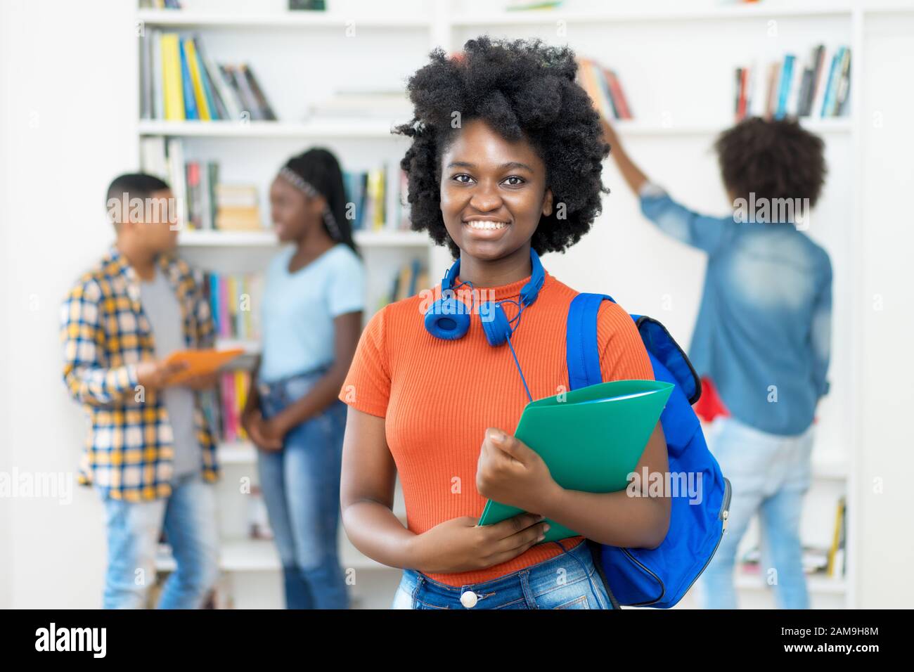 Bella studentessa afroamericana con gruppo di studenti in classe universitaria Foto Stock