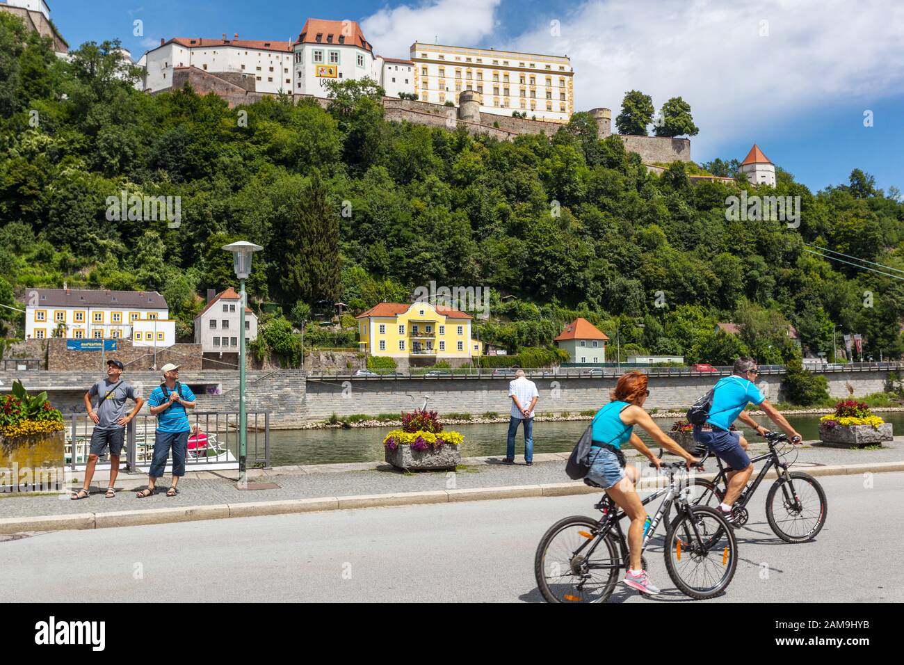 Germania turisti camminare sul lungomare al molo, Passau Danubio fiume Germania ciclisti Foto Stock