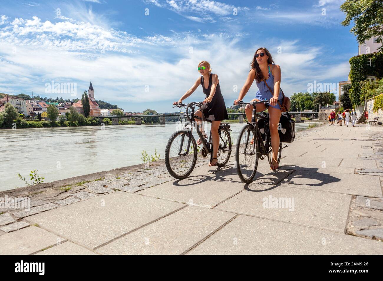 Passau Germania Baviera ciclista tedesca giovani donne ciclisti in bicicletta lungo il fiume Inn, godendo di uno splendido paesaggio estivo in bicicletta insieme amici donne tedesche Foto Stock