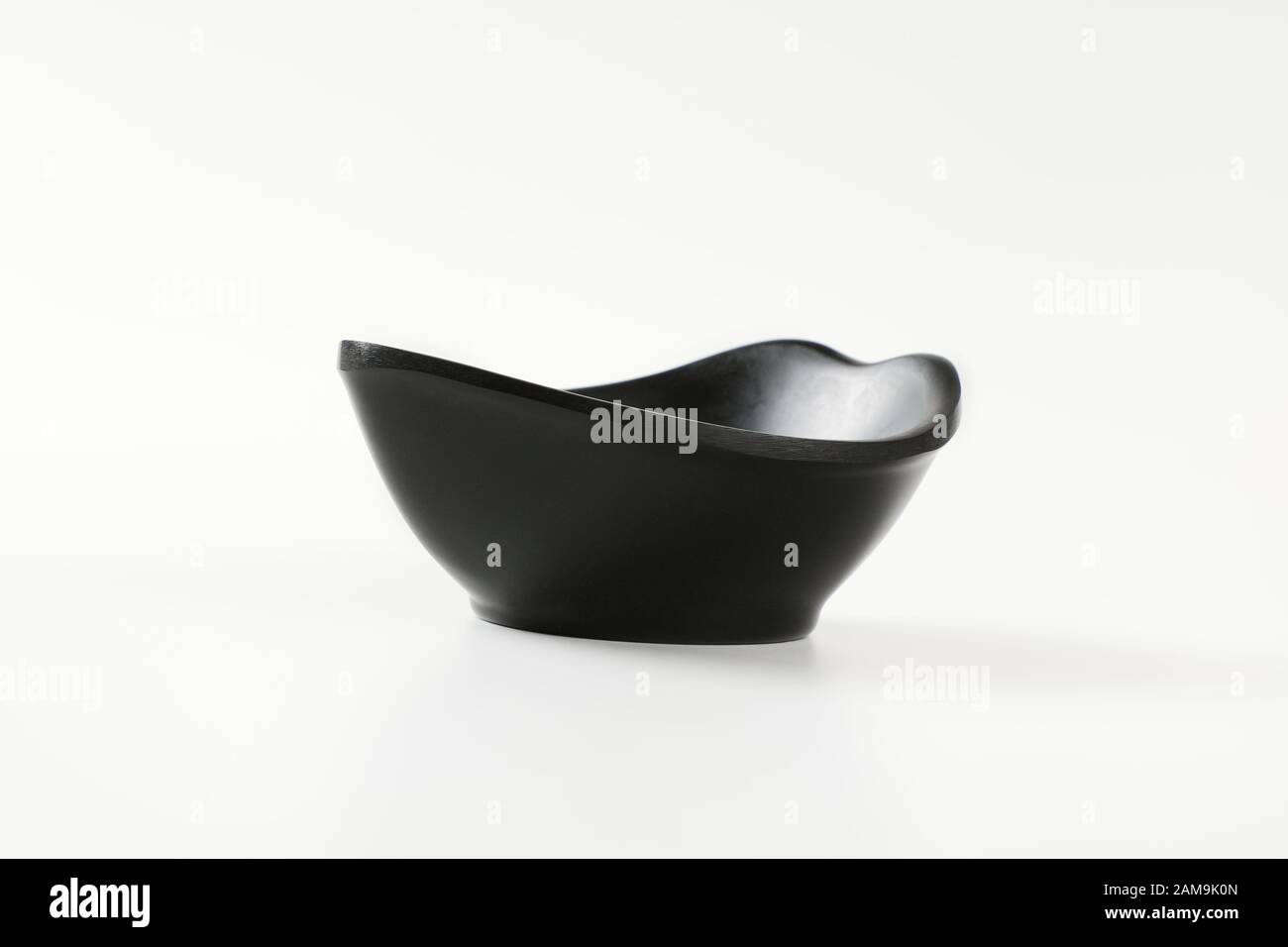 Ciotola nera curva per servire spuntini e noci Foto Stock