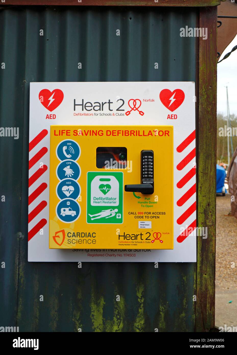 Un defibrillatore salvavita in un luogo pubblico di un cantiere nel Norfolk Broads nel villaggio di Belaugh, Norfolk, Inghilterra, Regno Unito, Europa. Foto Stock
