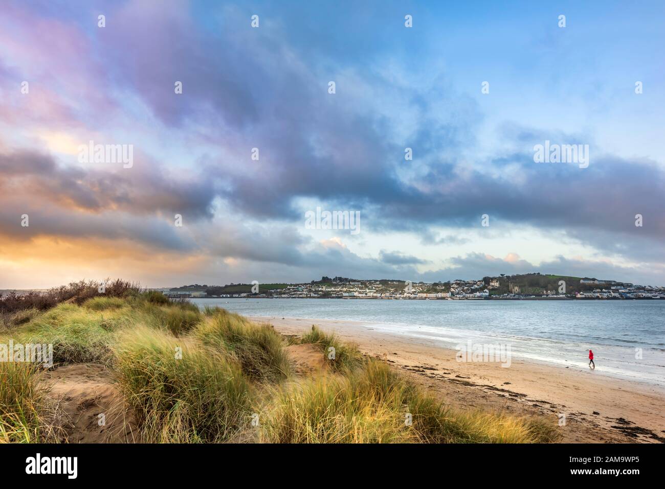 Instow, North Devon, Regno Unito. 12th gennaio 2020. Meteo Regno Unito. Mentre il sole sorge, una brezza fredda increspa le erbe lunghe sulle dune, mentre la gente gode di una camminata a rischio sulla spiaggia spazzata dal vento a Instow nel Devon del Nord. Terry Mathews/Alamy Live News Foto Stock