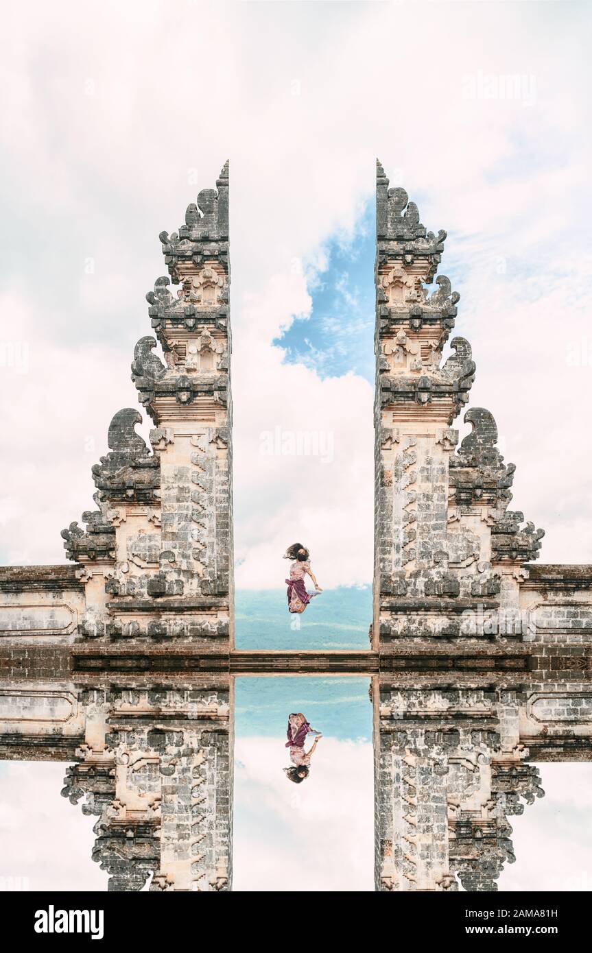 Una ragazza sta saltando davanti alla porta del Cielo con il suo riflesso nell'acqua. Foto Stock
