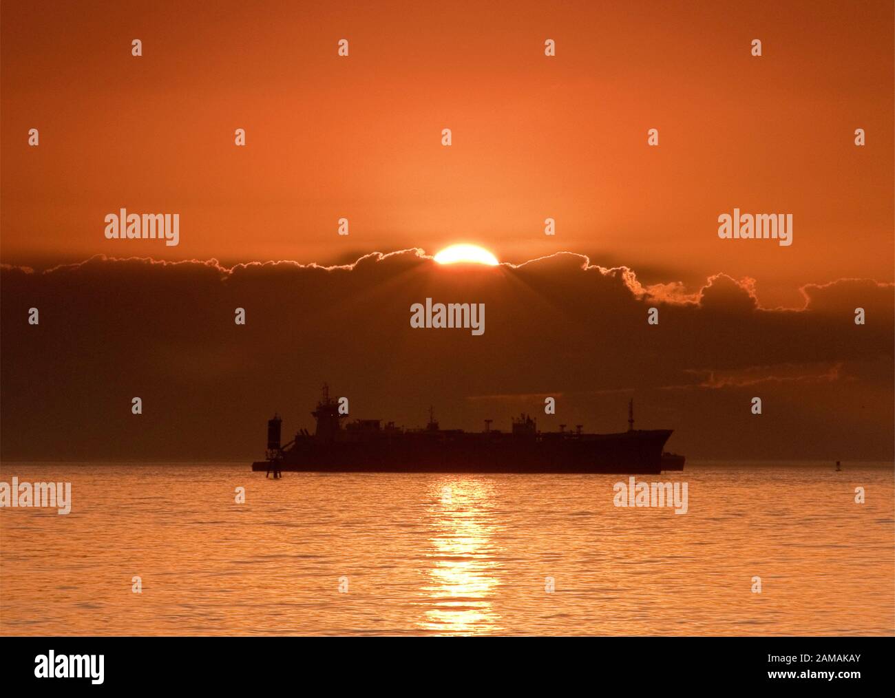 Le navi in attesa al di ancoraggio nel Golfo del Messico presso sunrise, prima di entrare in Galveston Bay sul loro modo al Porto di Houston, Texas, Stati Uniti d'America Foto Stock