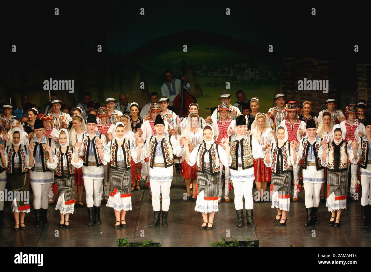 I ballerini professionisti del Banatul Folklore Ensemble tengono le mani in una danza tradizionale rumena indossando costumi tradizionali belli. Foto Stock