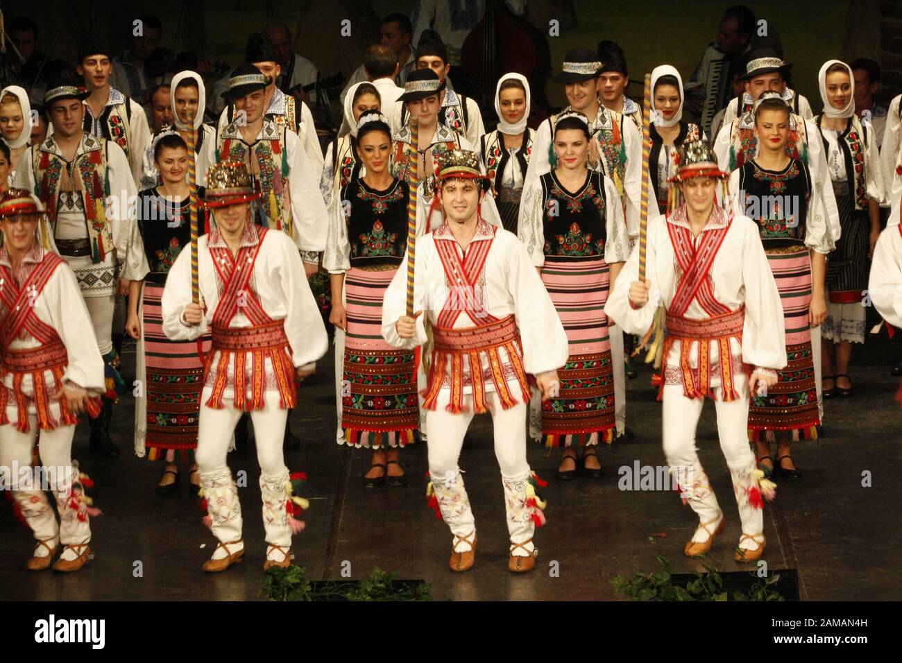 I ballerini professionisti del Banatul Folklore Ensemble tengono le mani in una danza tradizionale rumena indossando costumi tradizionali belli. Foto Stock