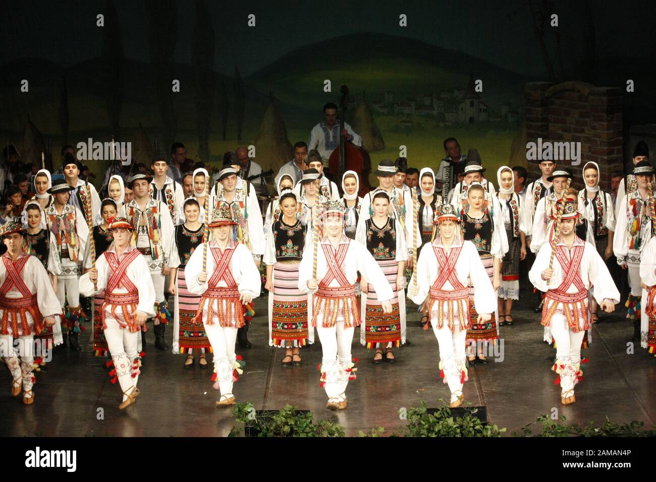 I ballerini professionisti del Banatul Folklore Ensemble tengono le mani in una danza tradizionale rumena indossando costumi tradizionali belli. Foto Stock