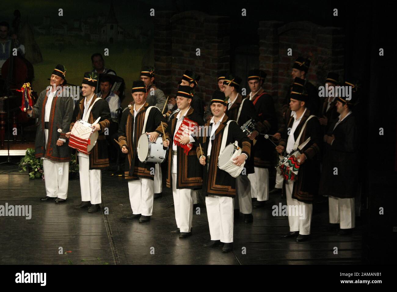 I ballerini professionisti del Banatul Folklore Ensemble tengono le mani in una danza tradizionale rumena indossando costumi tradizionali belli. Foto Stock