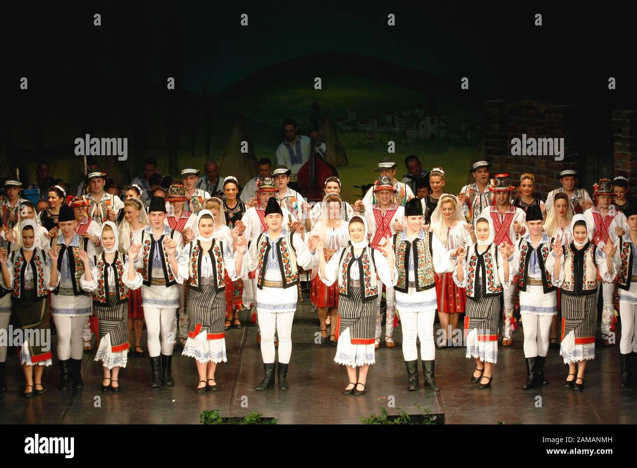 I ballerini professionisti del Banatul Folklore Ensemble tengono le mani in una danza tradizionale rumena indossando costumi tradizionali belli. Foto Stock