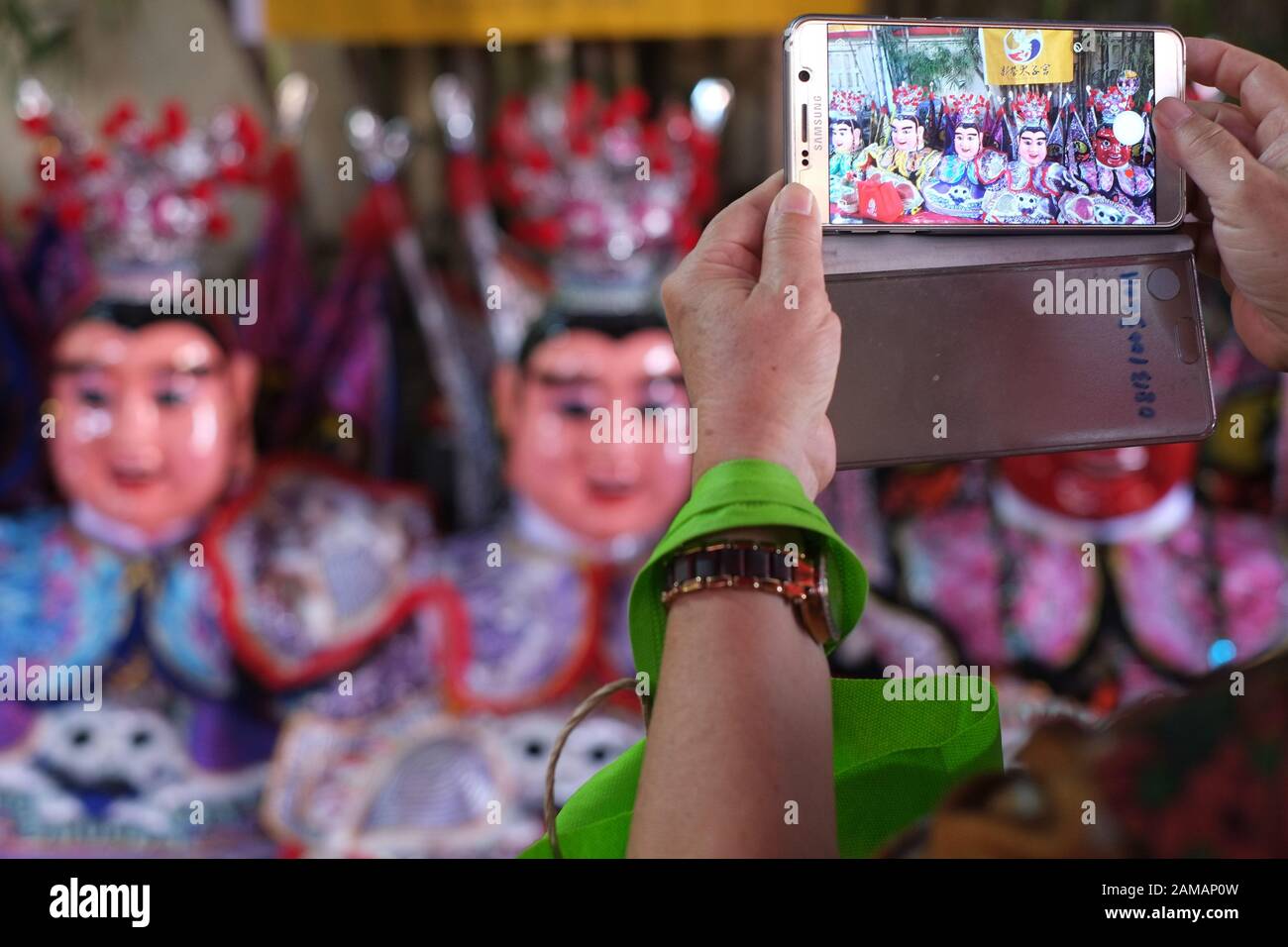 Una persona di utilizzare una fotocamera dello smartphone per scattare foto di burattini Taiwanesi nella celebrazione del Capodanno cinese festival. Foto Stock