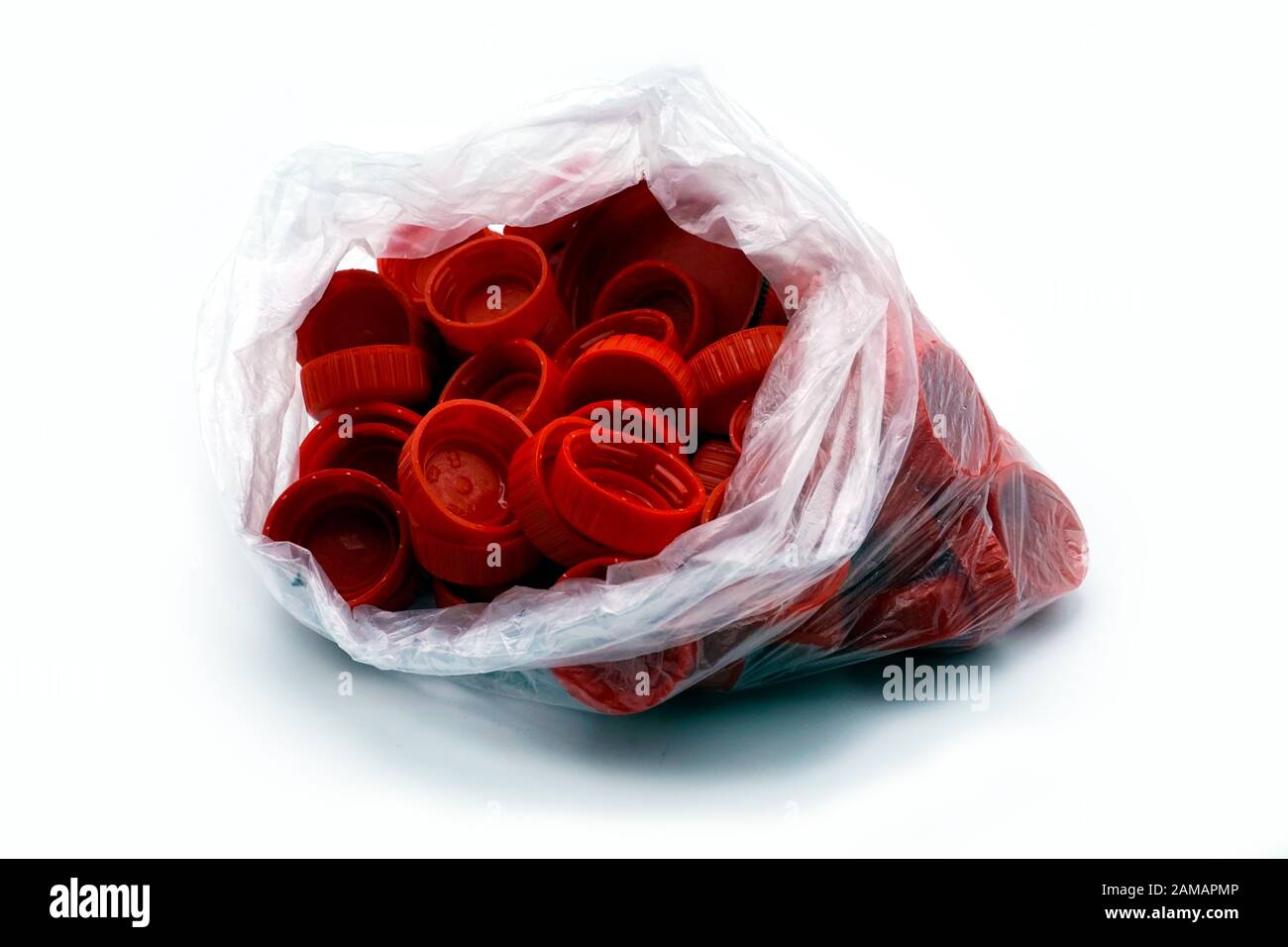 Tappi per bottiglie in plastica rossa ordinati per colori in sacchetti di plastica monouso trasparenti. PP un inquinamento PET. Soluzioni per il riciclaggio dei rifiuti in plastica. Foto Stock