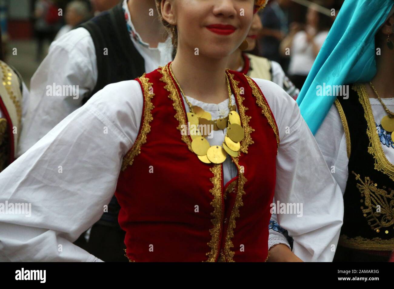 I ballerini professionisti del Timisul Folklore Ensemble tengono le mani in una danza tradizionale rumena indossando costumi tradizionali belli. Foto Stock