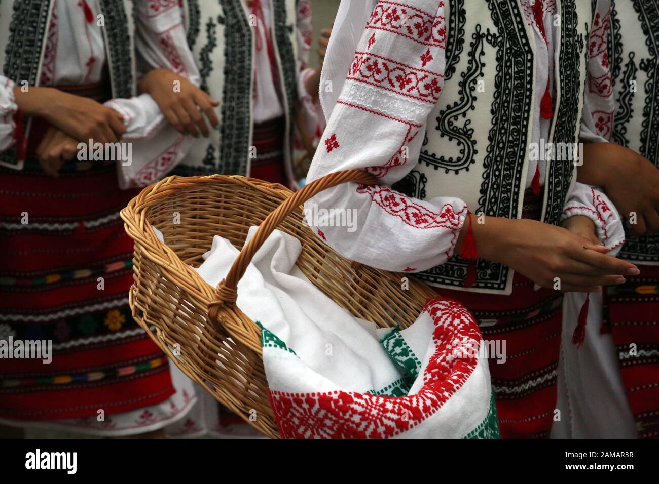 I ballerini professionisti del Timisul Folklore Ensemble tengono le mani in una danza tradizionale rumena indossando costumi tradizionali belli. Foto Stock