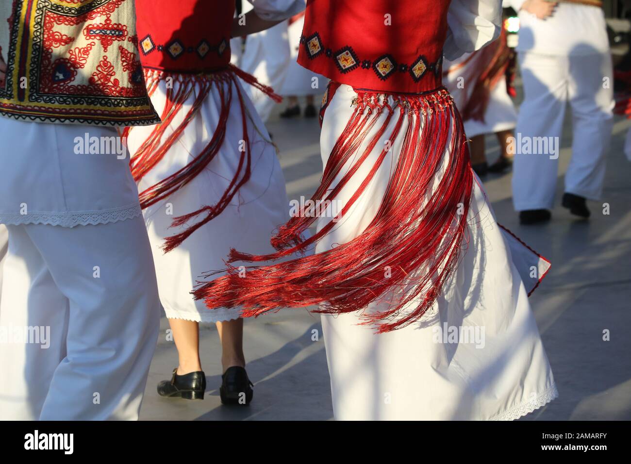 I ballerini professionisti del Timisul Folklore Ensemble tengono le mani in una danza tradizionale rumena indossando costumi tradizionali belli. Foto Stock