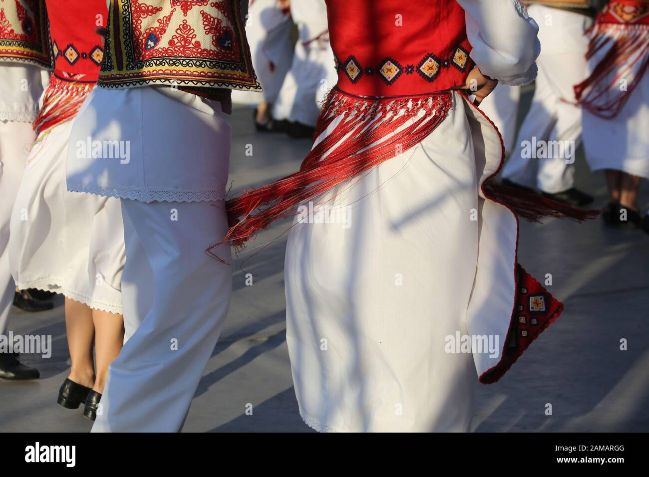 I ballerini professionisti del Timisul Folklore Ensemble tengono le mani in una danza tradizionale rumena indossando costumi tradizionali belli. Foto Stock