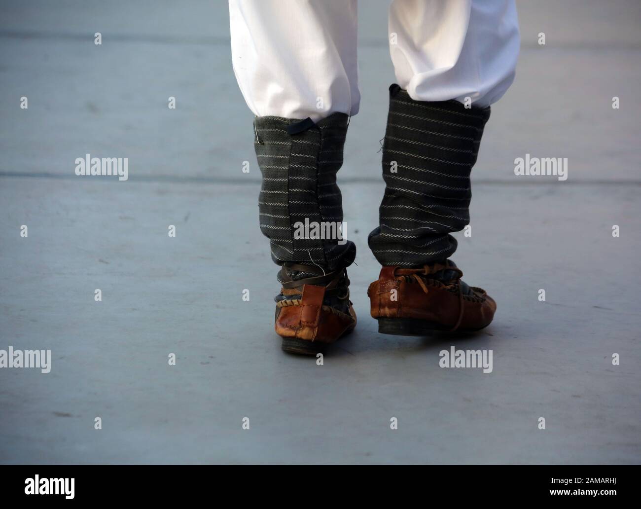 Dancersfeet in una danza tradizionale rumena indossando costumi tradizionali belli. Primo piano di scarpe folcloristiche. Foto Stock
